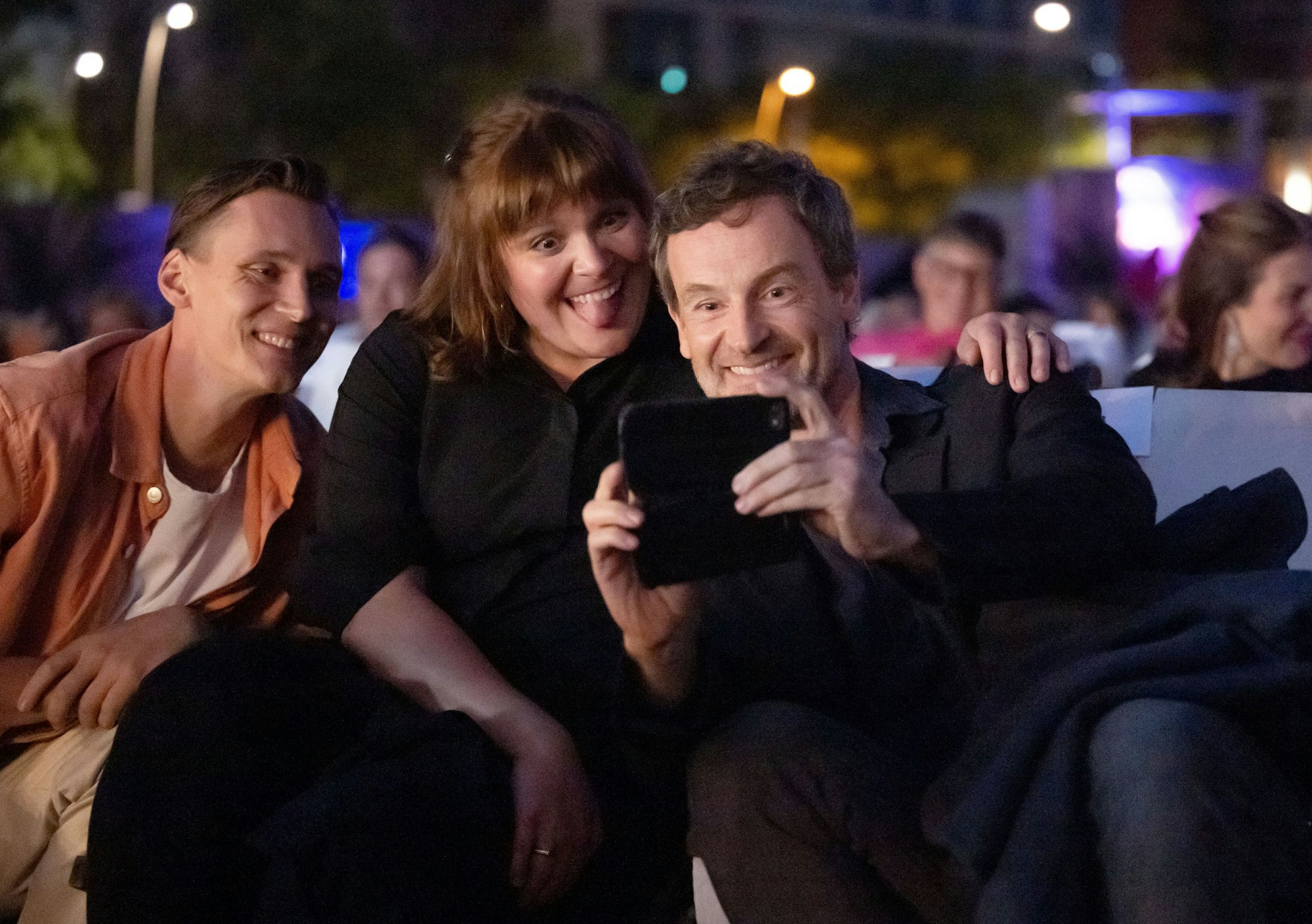 Jörg Hartmann, Stefanie Reinsperger und Rick Okon sitzen nebeneinander und machen ein Selfie.