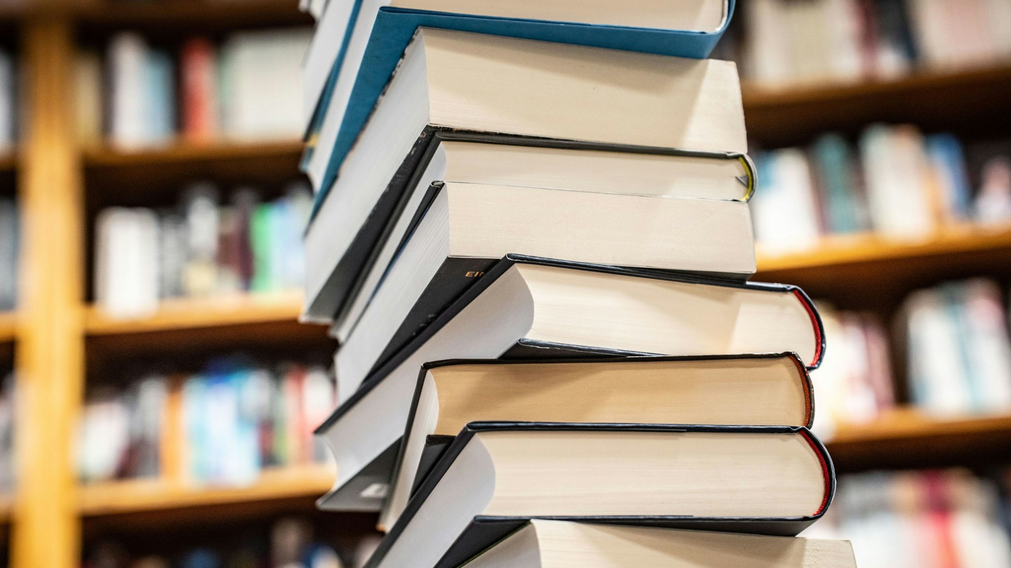 Ein Stapel mit neu erschienenen Büchern liegt in einer Buchhandlung auf einem Verkaufstisch.