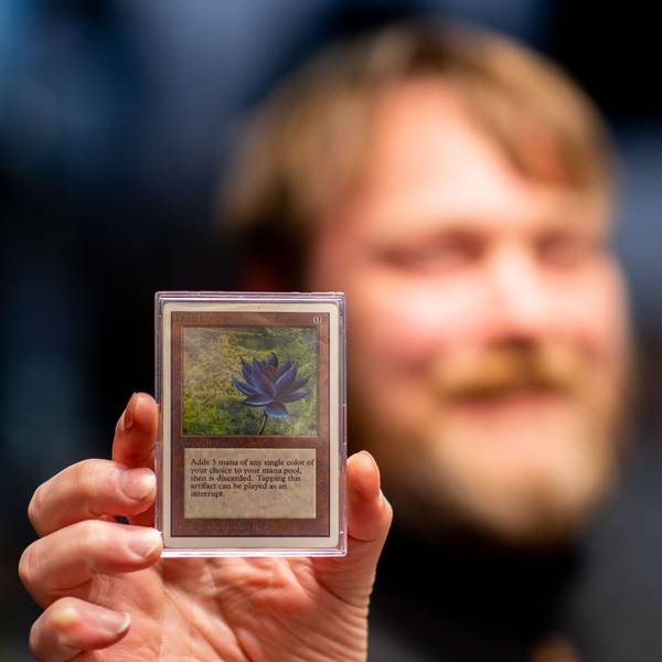 Der Besitzer des Fantasy Store in Euskirchen hält eine seltene Spielkarte in der Hand.