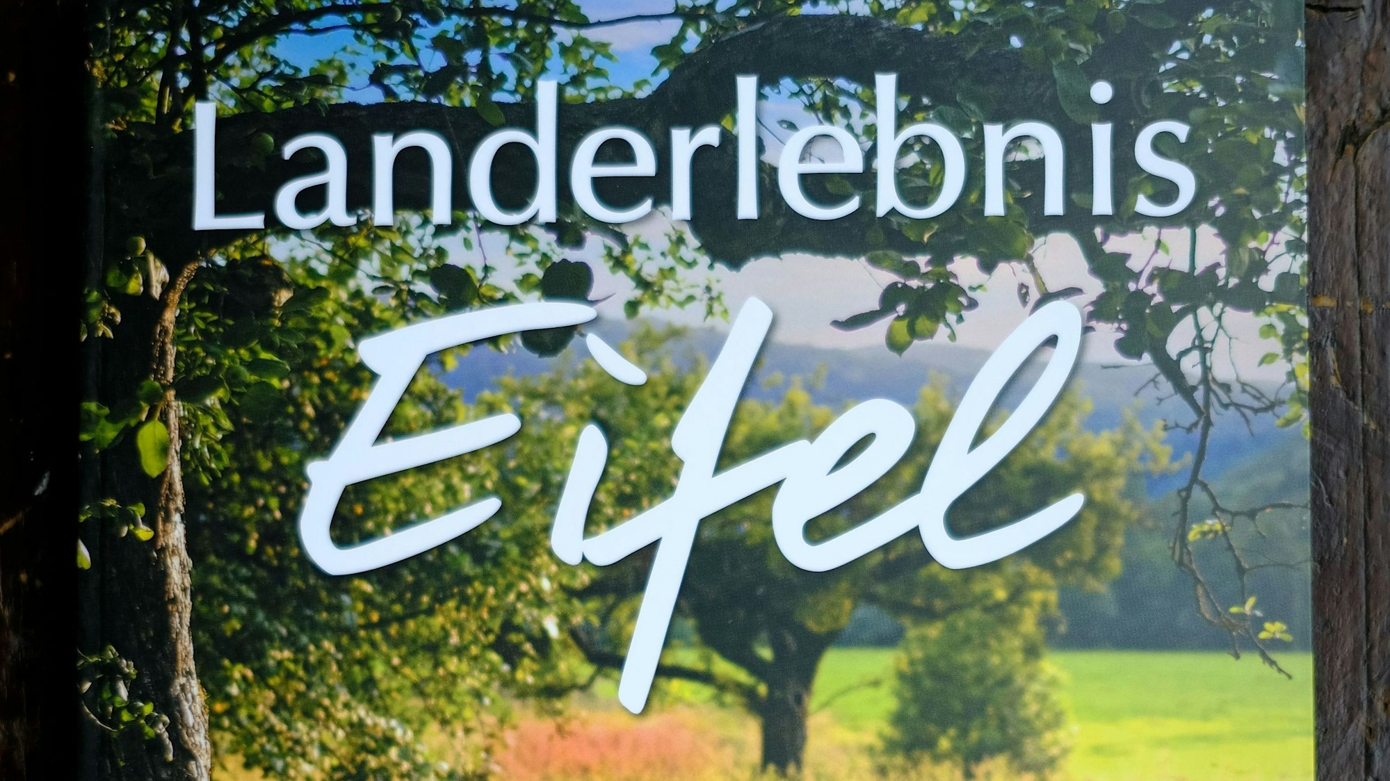 Das Cover ziert eine Fotografie von einer Obstwiese. In weißer Schrift ist der Titel des Buches geschrieben.