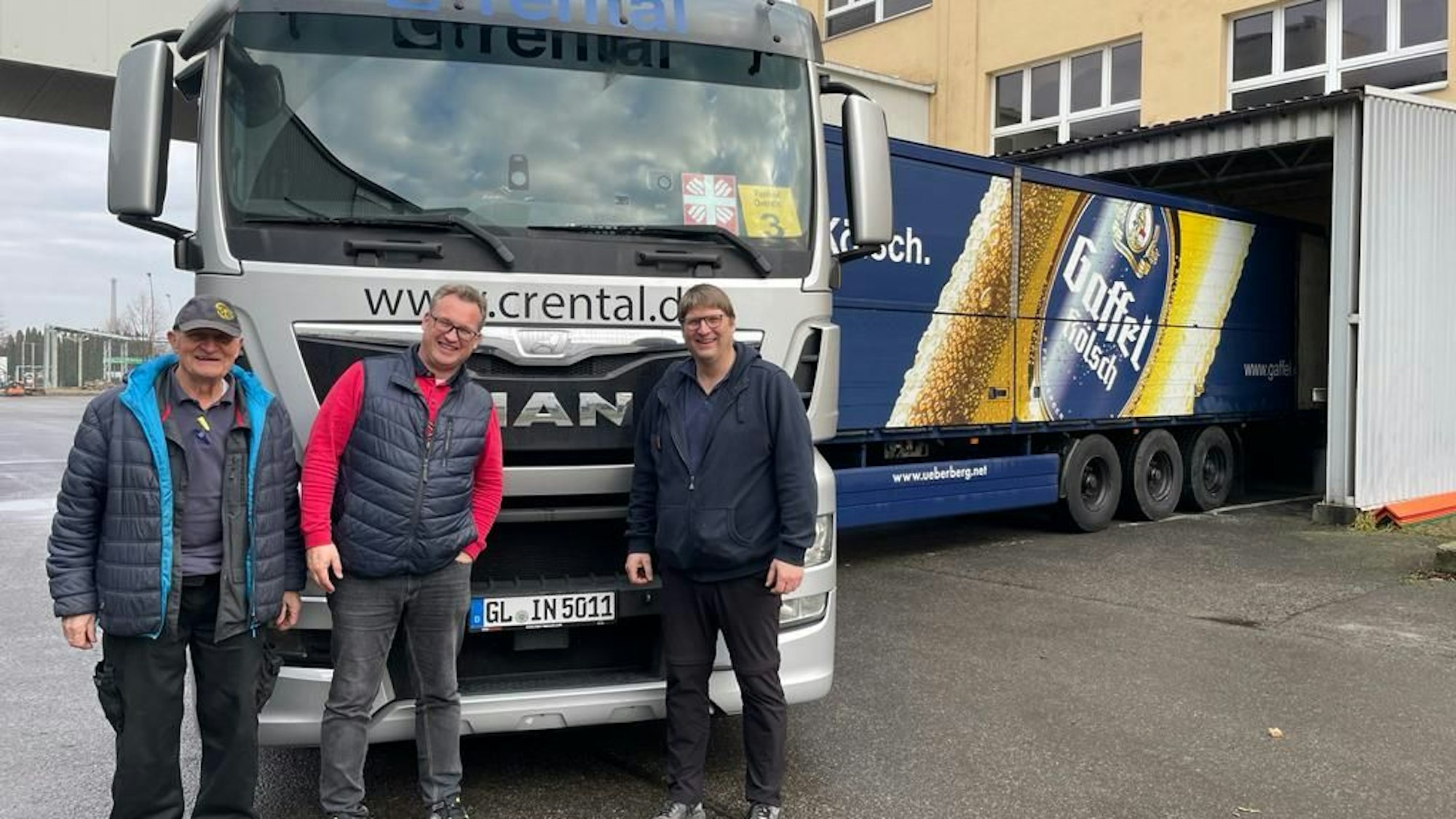 Drei Männer stehen vor einem Lastzug in Overath.