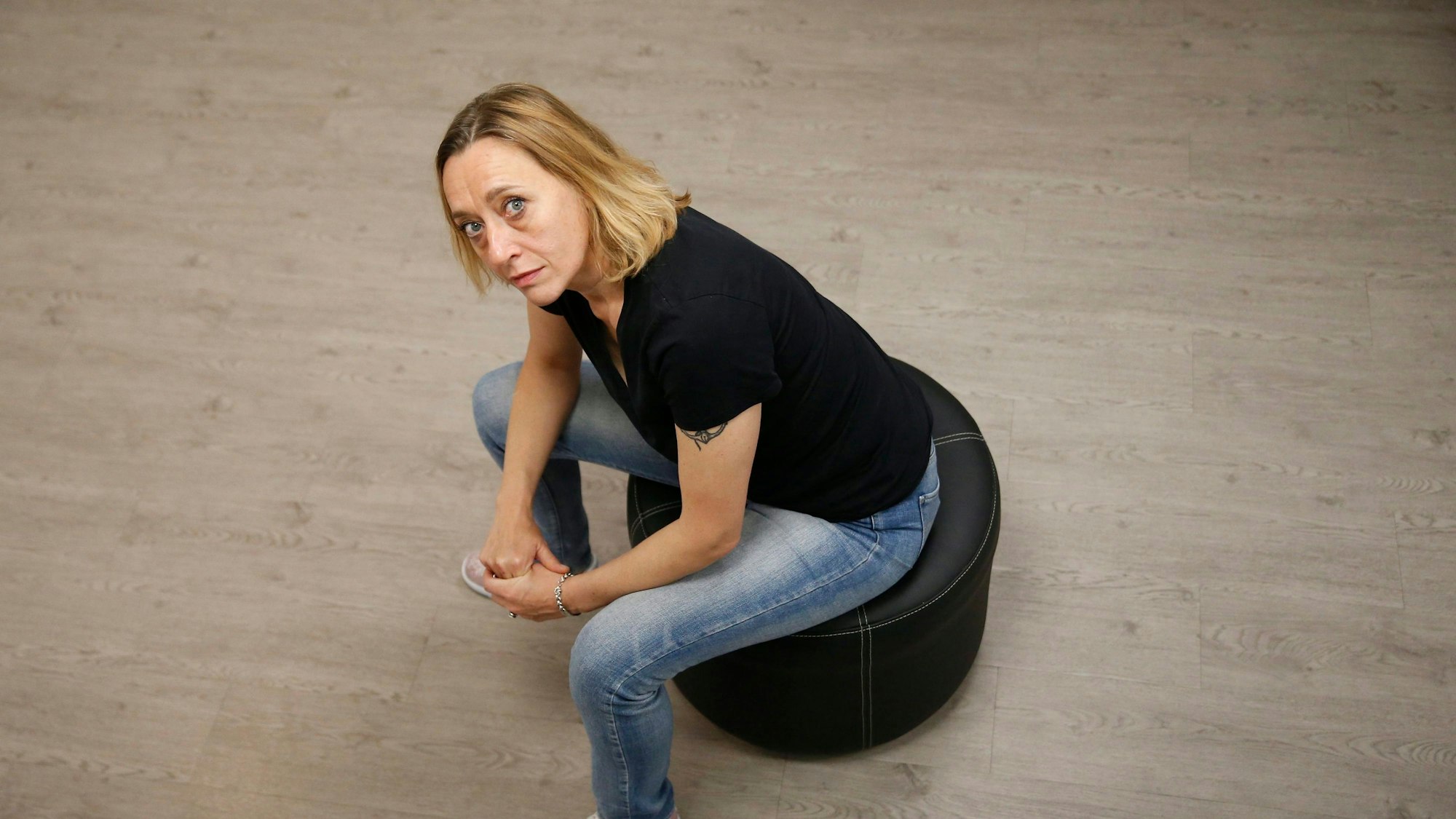 Virginie Despentes sitzt auf einem Hocker und blickt in die Kamera
