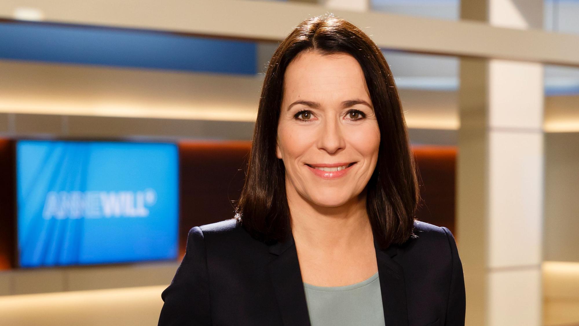Moderatorin Anne Will steht im Studio vor dem Logo der Sendung „Anne Will“