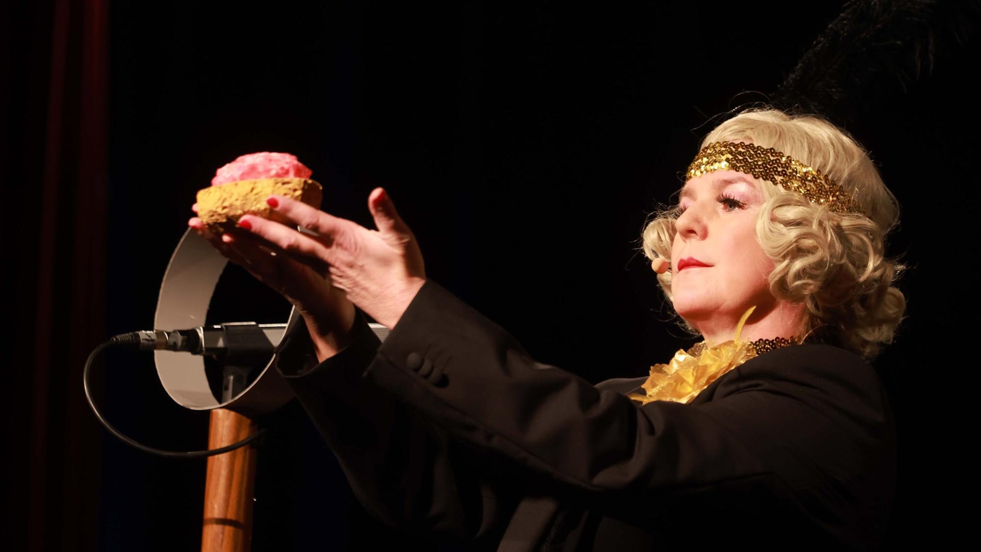 Mirja Boes hält ein Mett-Brot im historischen Kostüm hoch.