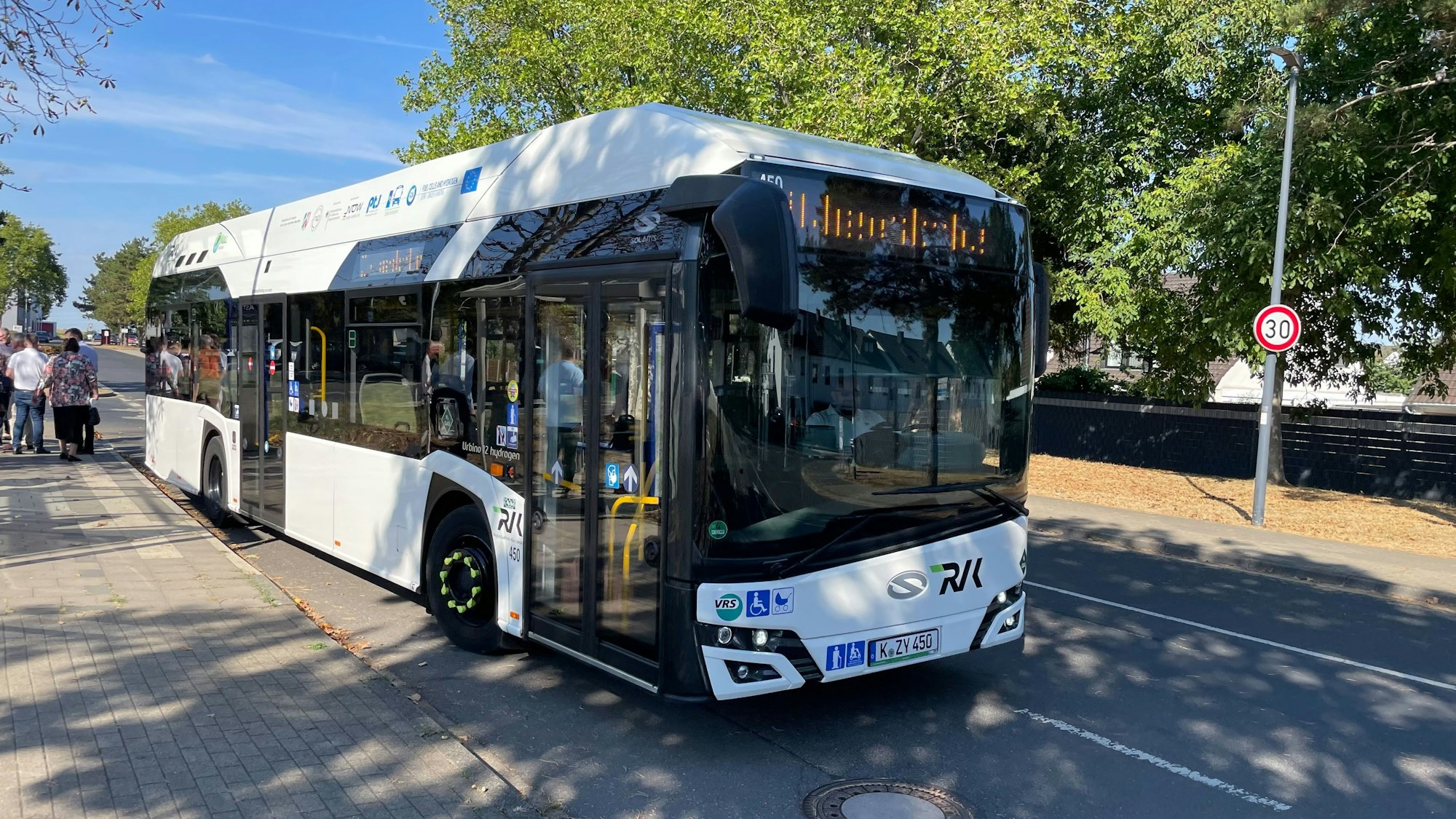 Ein RVK-Bus steht an einer Haltestelle.