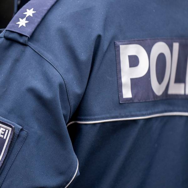Die Aufschrift Polizei und der Wappen von Berlin auf der Uniform eines Polizeibeamten