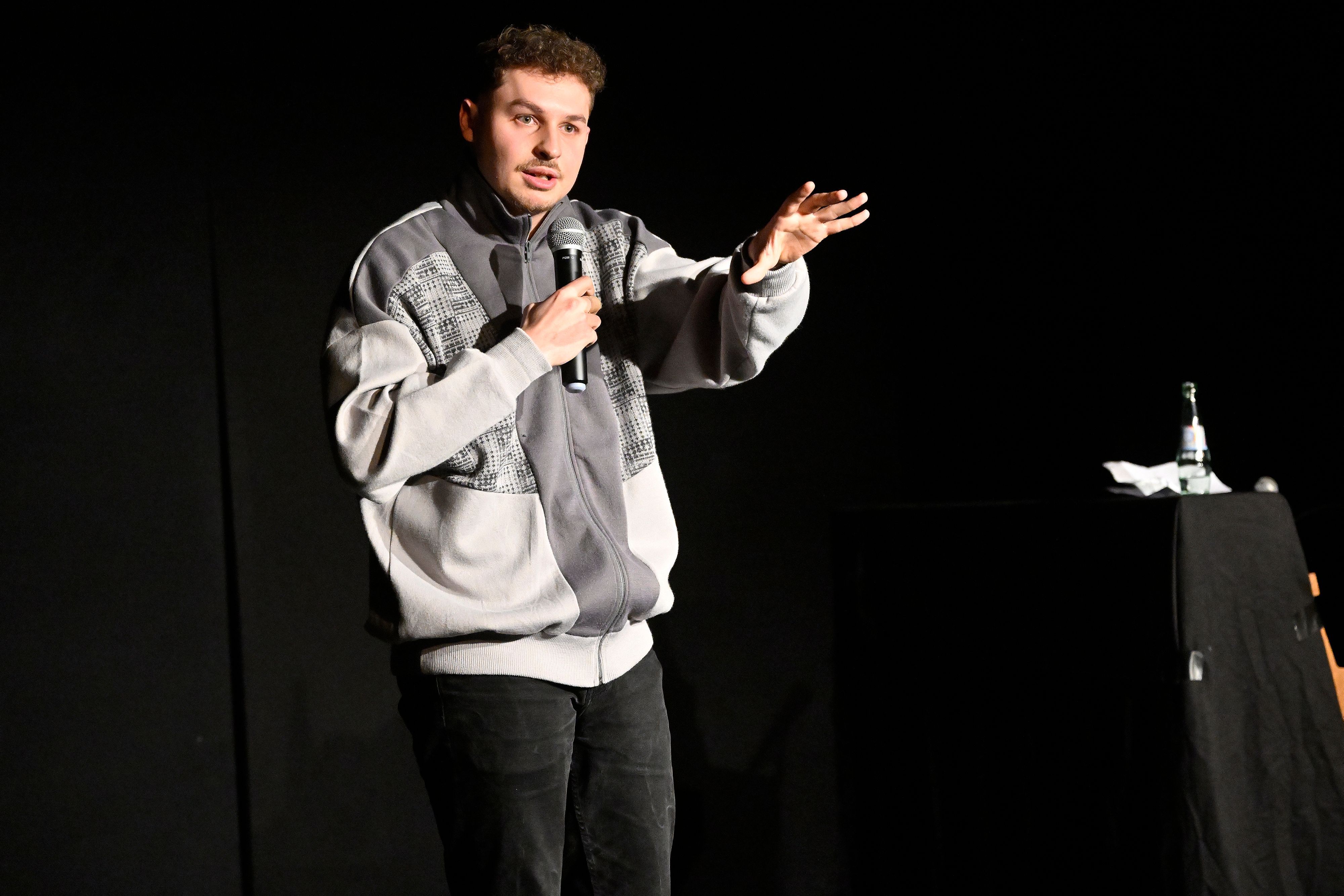 Fabian Lampert steht auf der Bühne vor dunklem Vorhang und referiert im Theas-Theater über Alkoholprobleme.