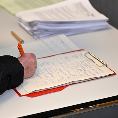 Jemand unterschreibt auf einer Liste.