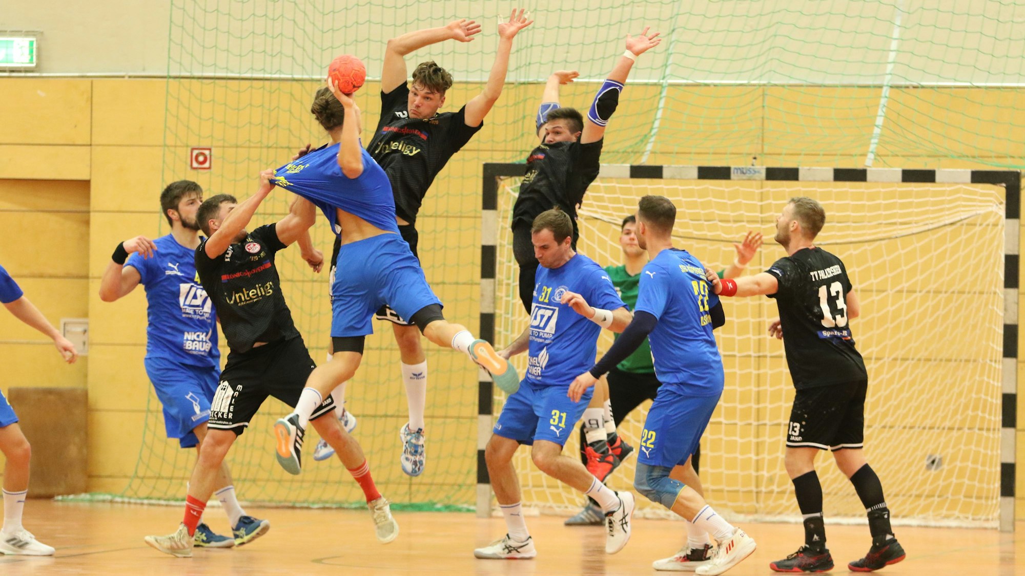 Angriff des SSV Nümbrecht: Zwei Palmersheimer Abwehrspieler werfen sich dem werfenden Spieler entgegen, ein dritter Palmersheimer zieht ihn am Trikot.