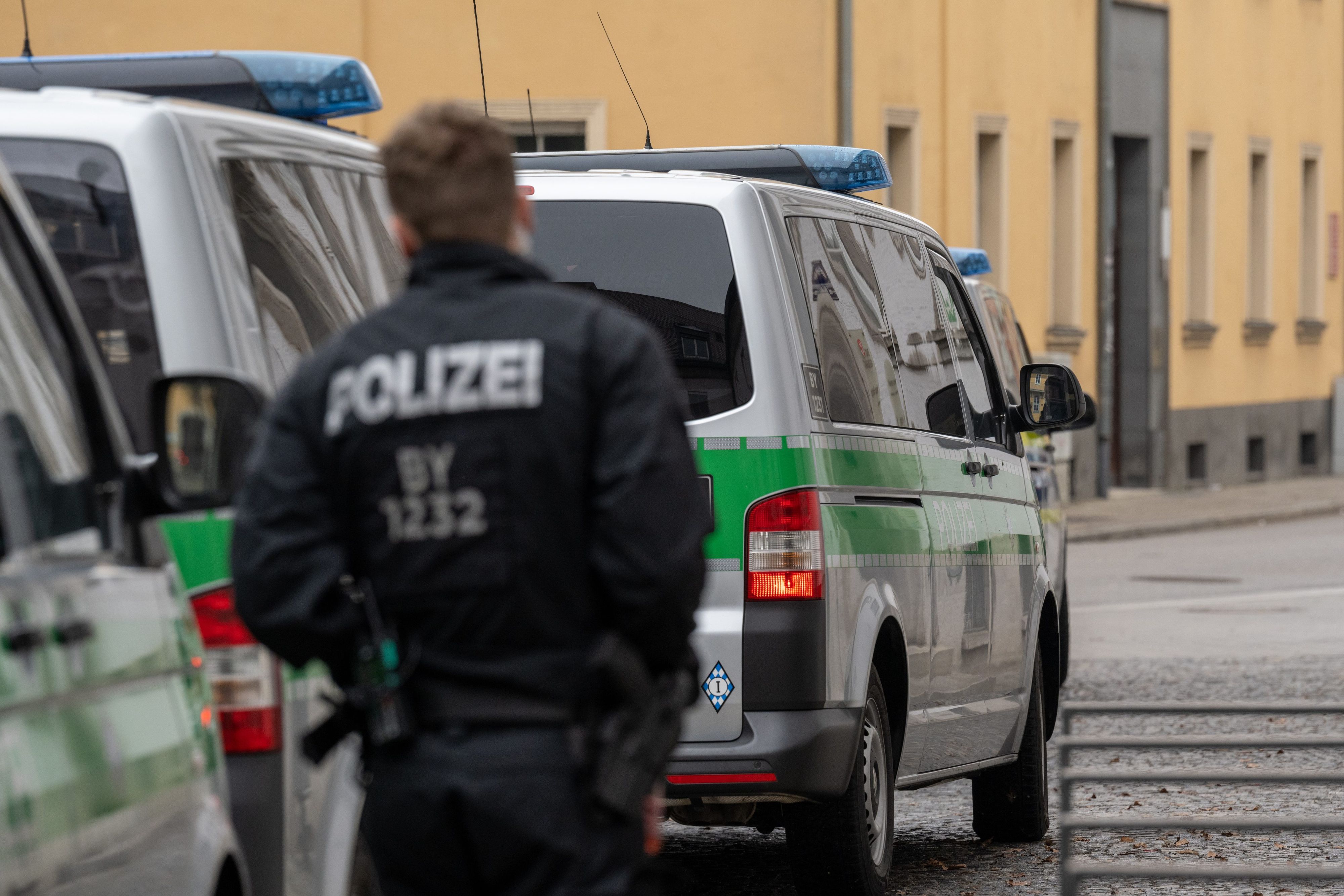 Polizeifahrzeuge und ein Polizist der Polizei Regensburg.