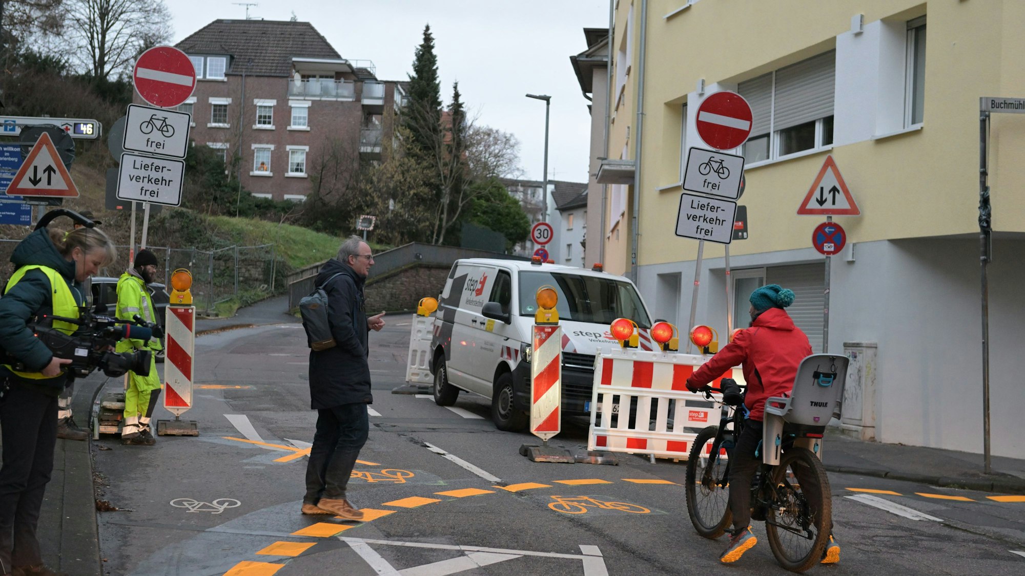 Ein Radfahrer und ein Fußgänger stehen vor der gesperrten Straße.