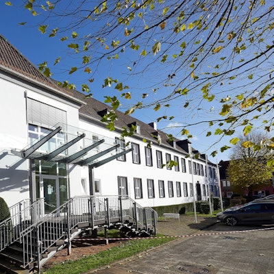 Ein Blick von außen auf das Amtsgericht in Gemünd: Das Gebäude ist weiß verputzt, vor dem Eingang sind zwei Treppen.