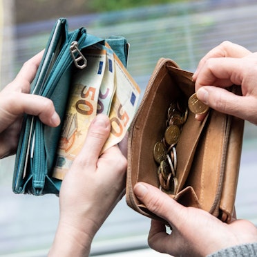 Zwei Menschen zeigen den Inhalt ihrer Geldbeutel. In einem sind Euro-Scheine (50er und 20er), im anderen nur Münzen.