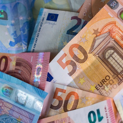 Zahlreiche Euro-Banknoten – 50er, 20er und 10er – liegen auf einem Tisch.