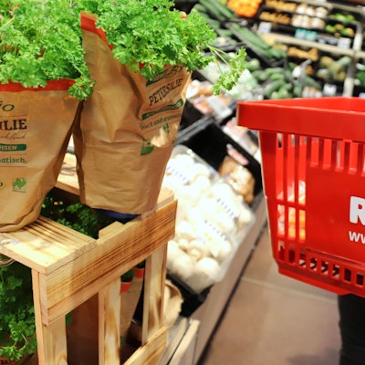 Ein Einkaufskorb in einem Rewe-Markt. Das Unternehmen setzt im Veganuary 2023 auf zahlreiche Angebote.