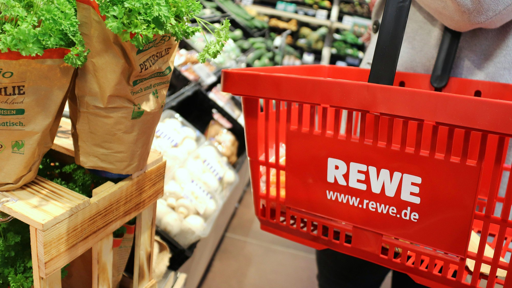 Ein Einkaufskorb in einem Rewe-Markt. Das Unternehmen setzt im Veganuary 2023 auf zahlreiche Angebote.