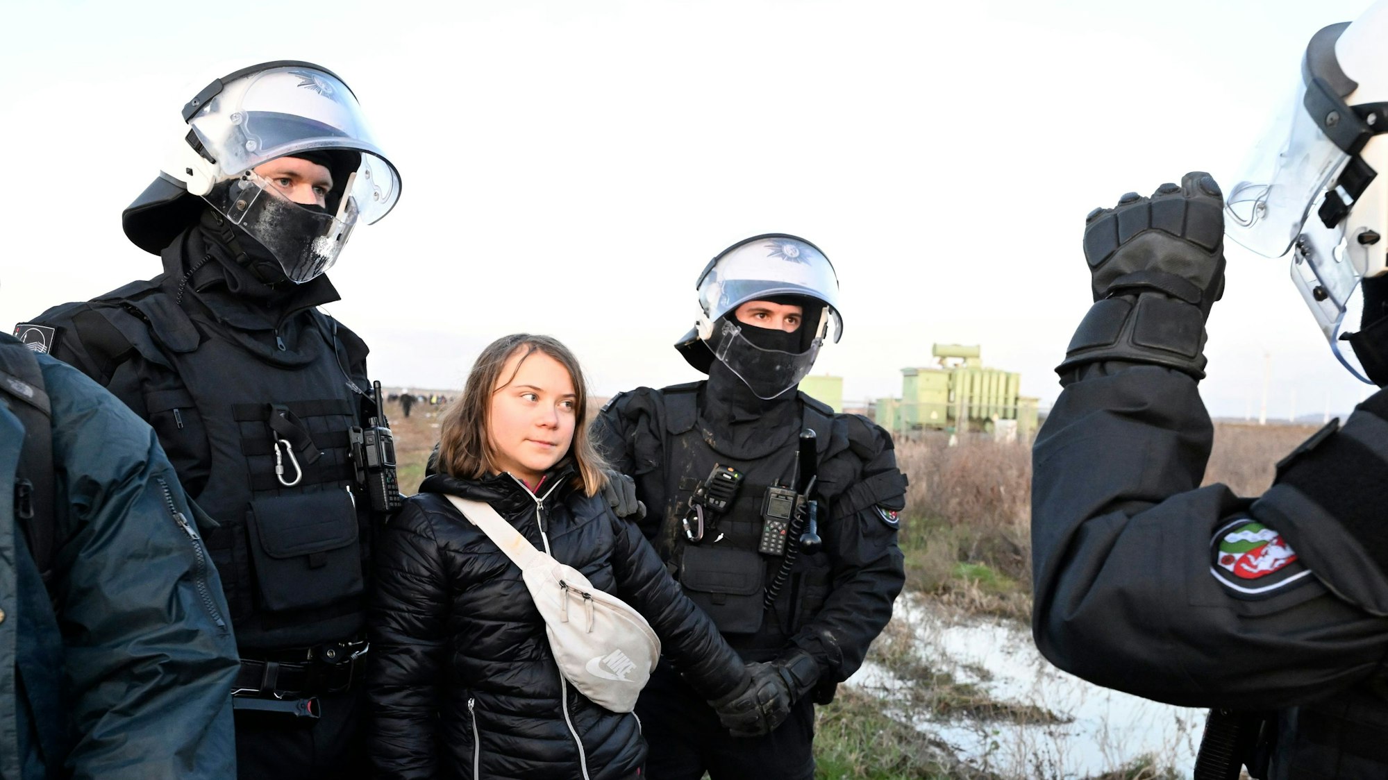 Polizisten haben die schwedische Klimaaktivistin Greta Thunberg (2.v.l.) aus einer Gruppe von Demonstranten und Aktivisten heraus und vom Rand des Braunkohlentagebaus Garzweiler II weggebracht und halten sie fest.
