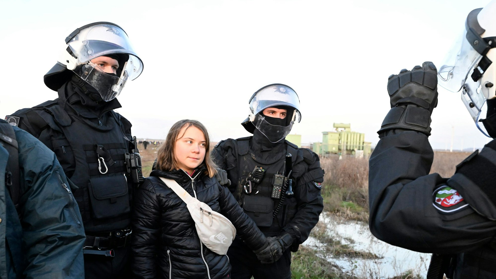 Polizisten haben die schwedische Klimaaktivistin Greta Thunberg (2.v.l.) aus einer Gruppe von Demonstranten und Aktivisten heraus und vom Rand des Braunkohlentagebaus Garzweiler II weggebracht und halten sie fest.