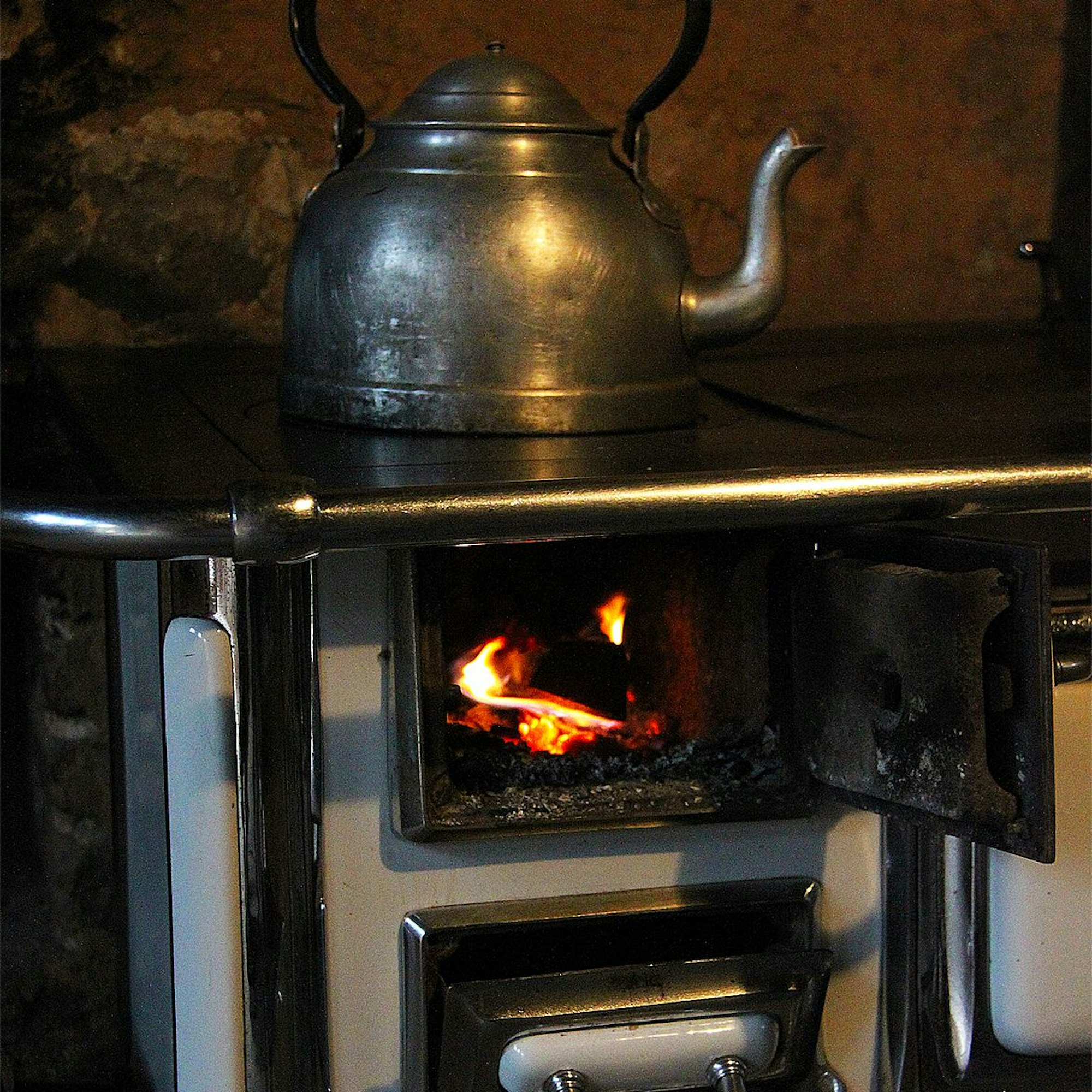 Im Freilichtmuseum Kommern ist ein Sparherd ausgestellt, in dem ein Feuer brennt.