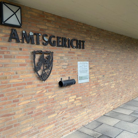 Ein Gebäude mit einer Klinkerwand, darauf der Schriftzug Amtsgericht und ein Wappen.
