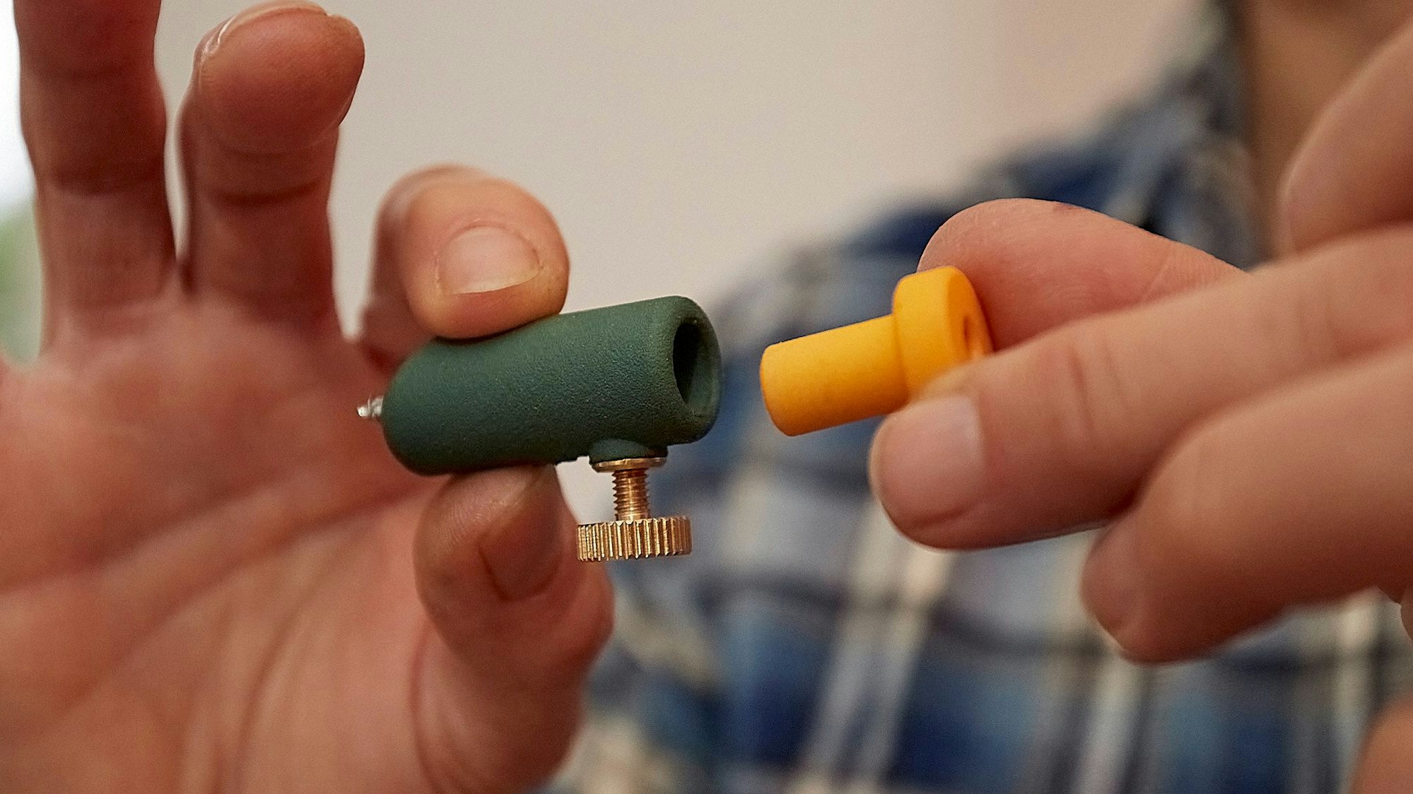 Eine Frau hält einen Adapter und eine Schraubhilfe in den Händen.