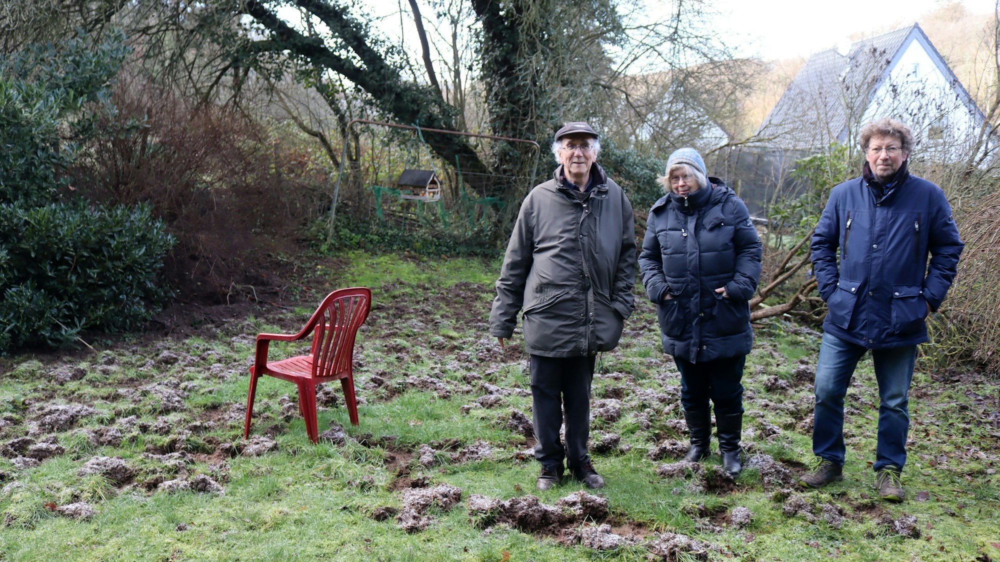 Siegfried Bauer (v.l.), Viola Pöschke-Bauer und Dieter Temming stehen im von Wildschweinen verwüsteten Garten der Bauers am Finkenweg in Bad Münstereifel.