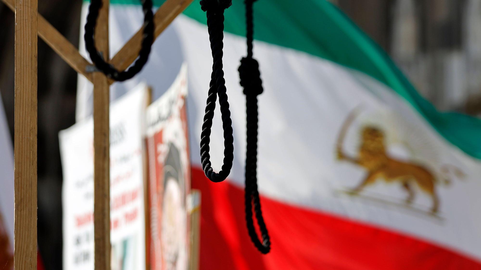 Eine Demonstration von Gegnern des Mullah-Regimes in Teheran fordert Solidarität mit der Opposition im Iran, die Abschaffung der Todesstrafe und einen Umsturz. Die Demonstranten halten iranische Flaggen und haben einige Galgen aus Holz aufgebaut, welche die martialischen Hinrichtungsmethoden im Iran veranschaulichen sollen. (Archivbild)