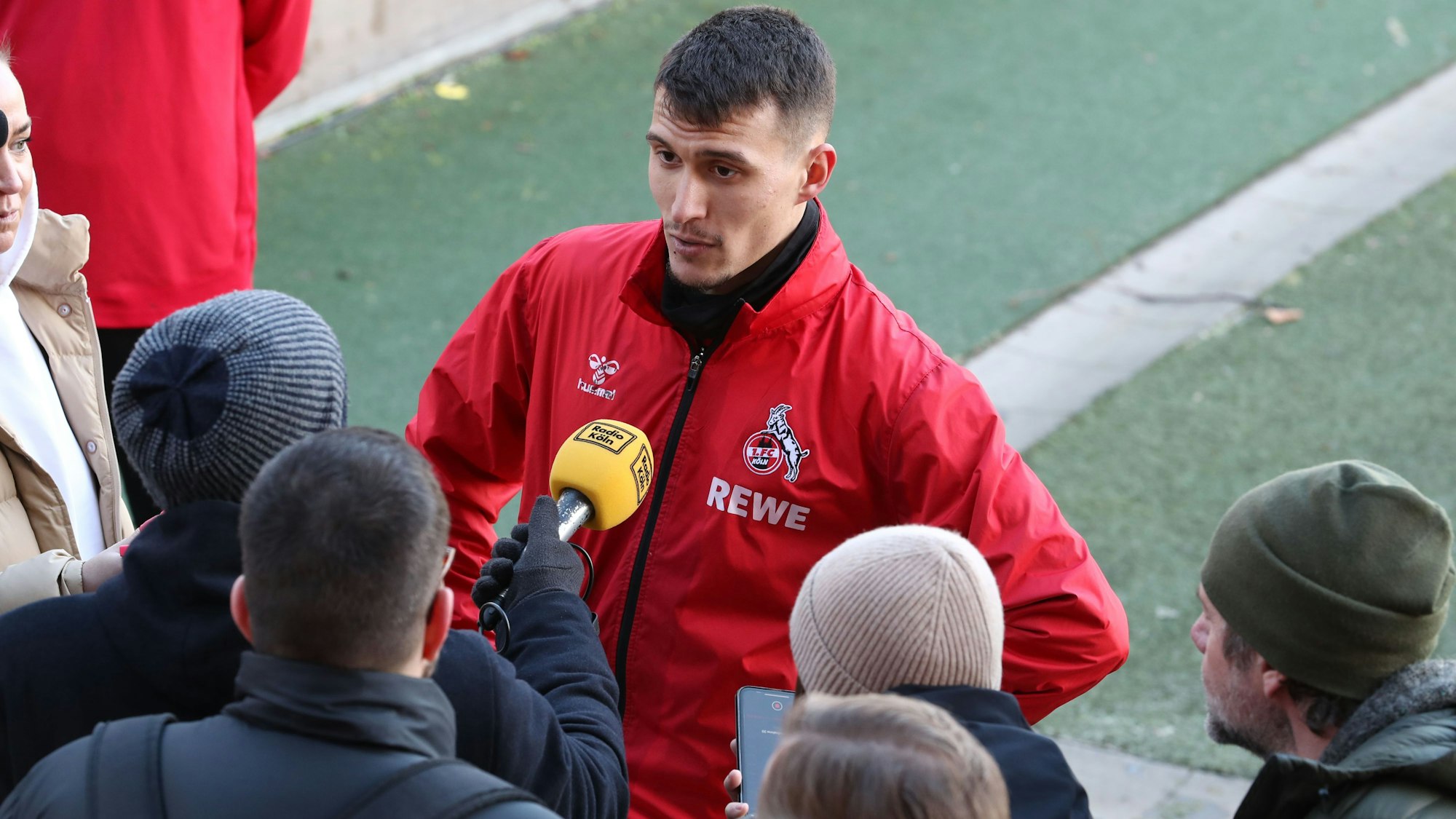 Dejan Ljubicic vom 1. FC Köln vor einem Reporter mit Mikrofon.