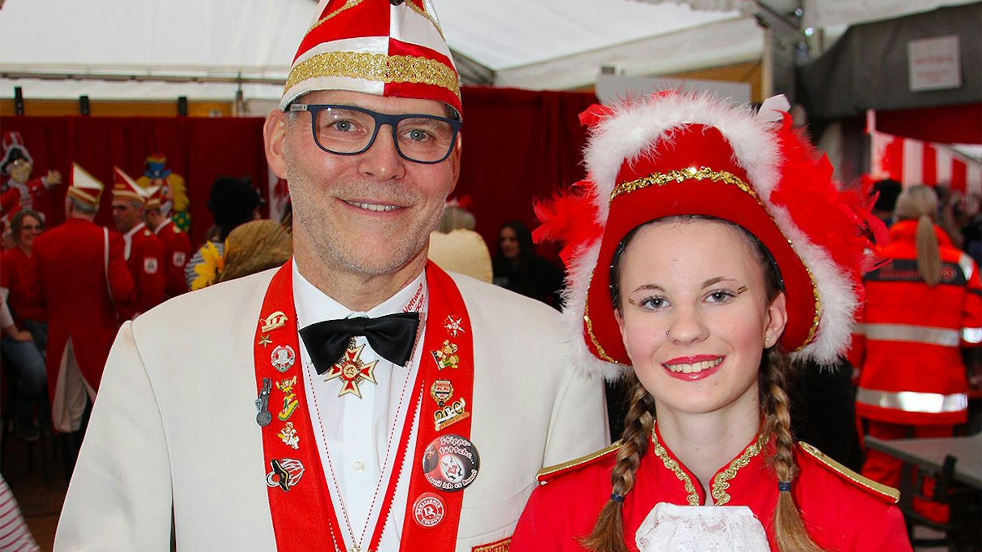 Ein Mann und eine Frau stehen in Karnevalskostümen in einem Festzelt.