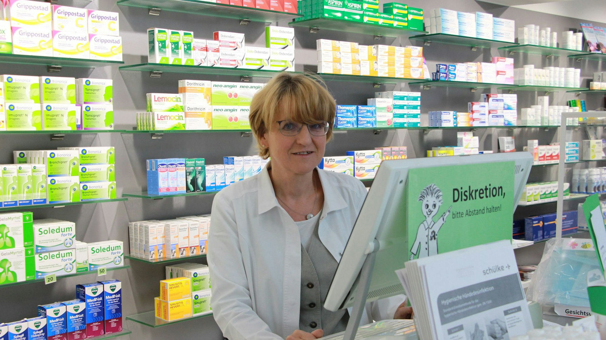 Eine Frau steht in einer Apotheke.