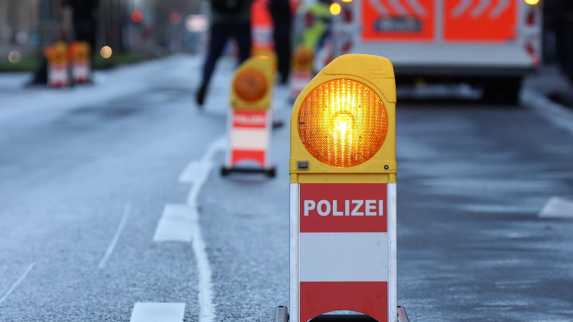 Eine Polizei-Warnbake steht auf einer Straße (Symbolbild)