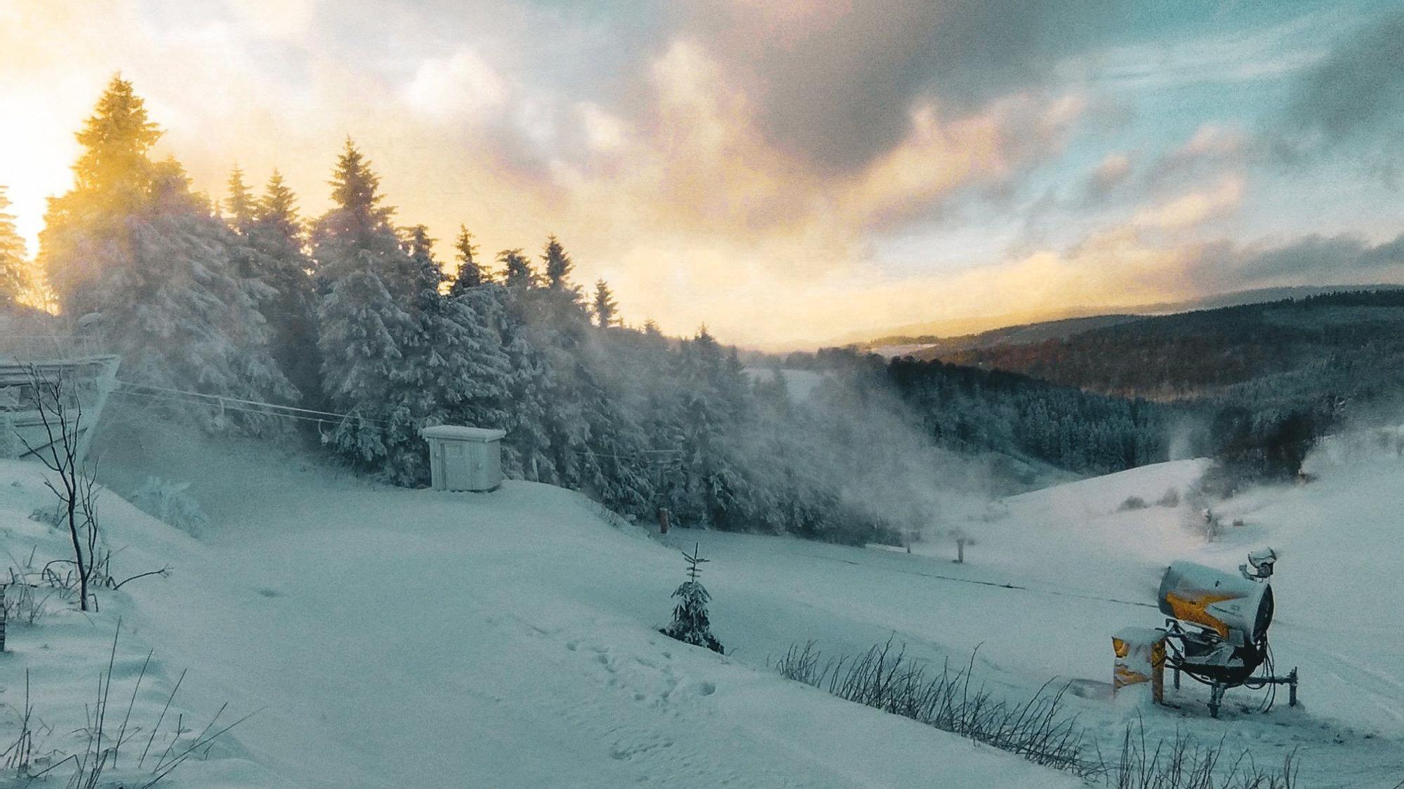 Eine Schneekanone wird an einem Hang im Sauerland eingesetzt.