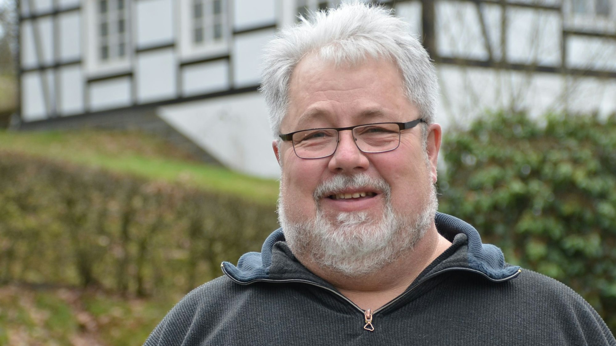 Porträt von Stephan Feldmann vor einem Fachwerkhaus.