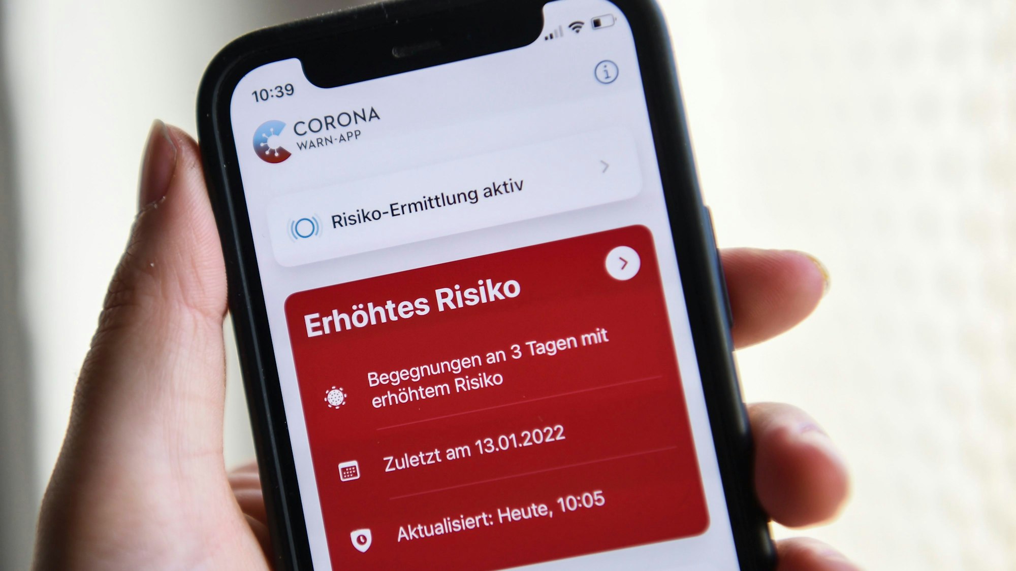 Auf einem Smartphone zeigt die geöffnete Corona-Warn-App ein erhöhtes Risiko an.
