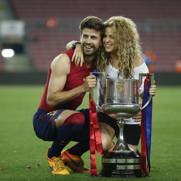 Gerard Pique posiert mit seiner Frau Shakira vor einem Pokal.
