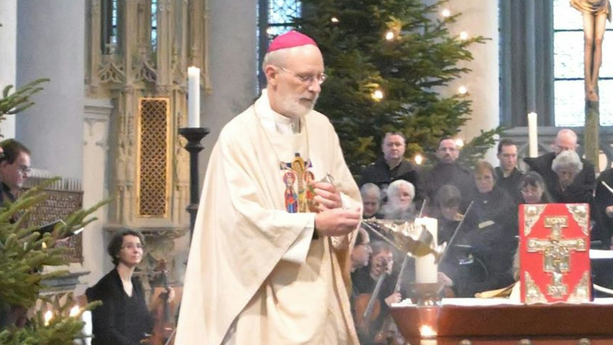 Weihbischof Ansgar Puff steht bei einer Messe im Altenberger Dom vor Gläubigen.