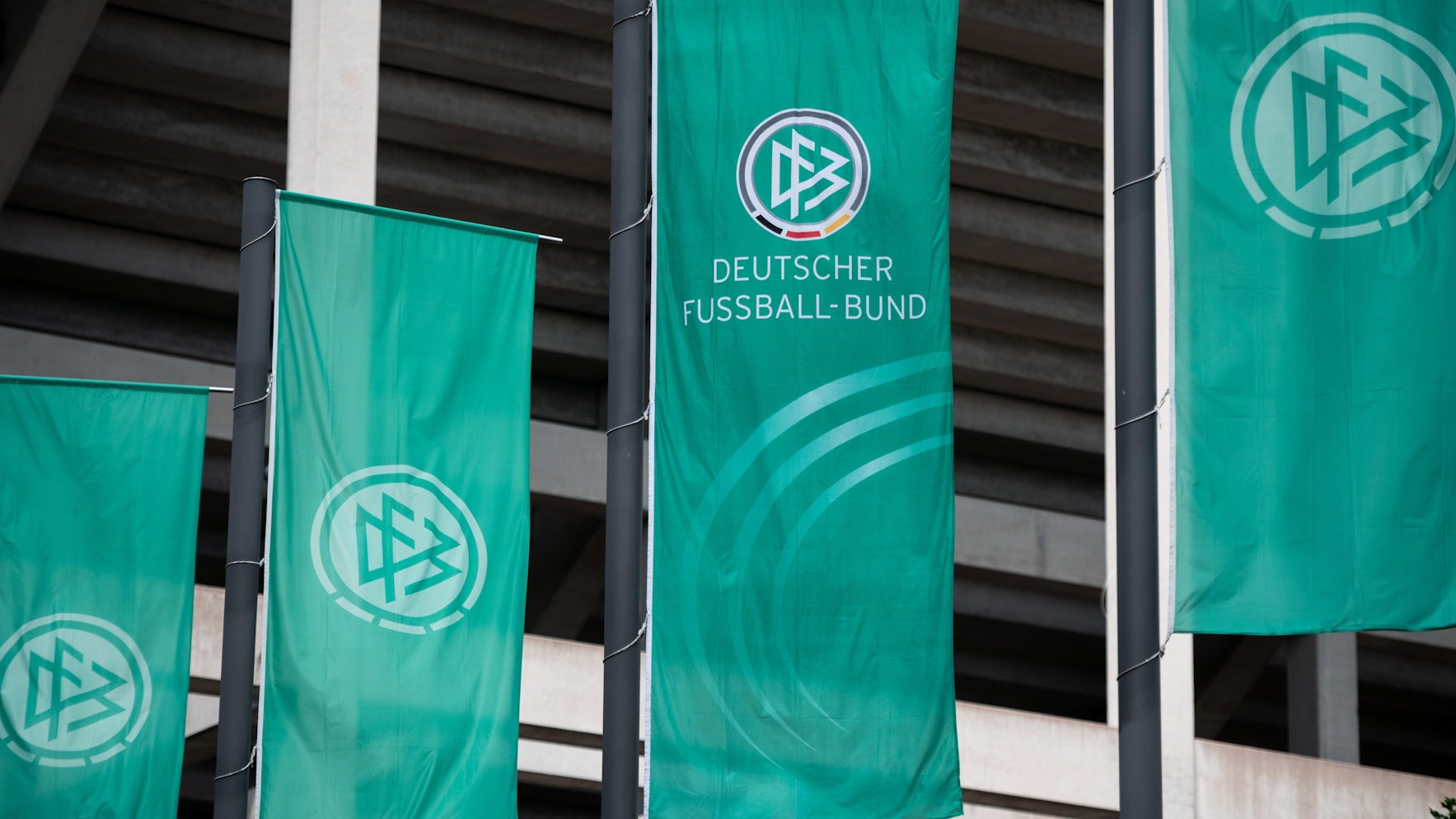 Fahnen mit dem Logo des Deutschen Fussball-Bund (DFB) wehen vor dem Stadion.