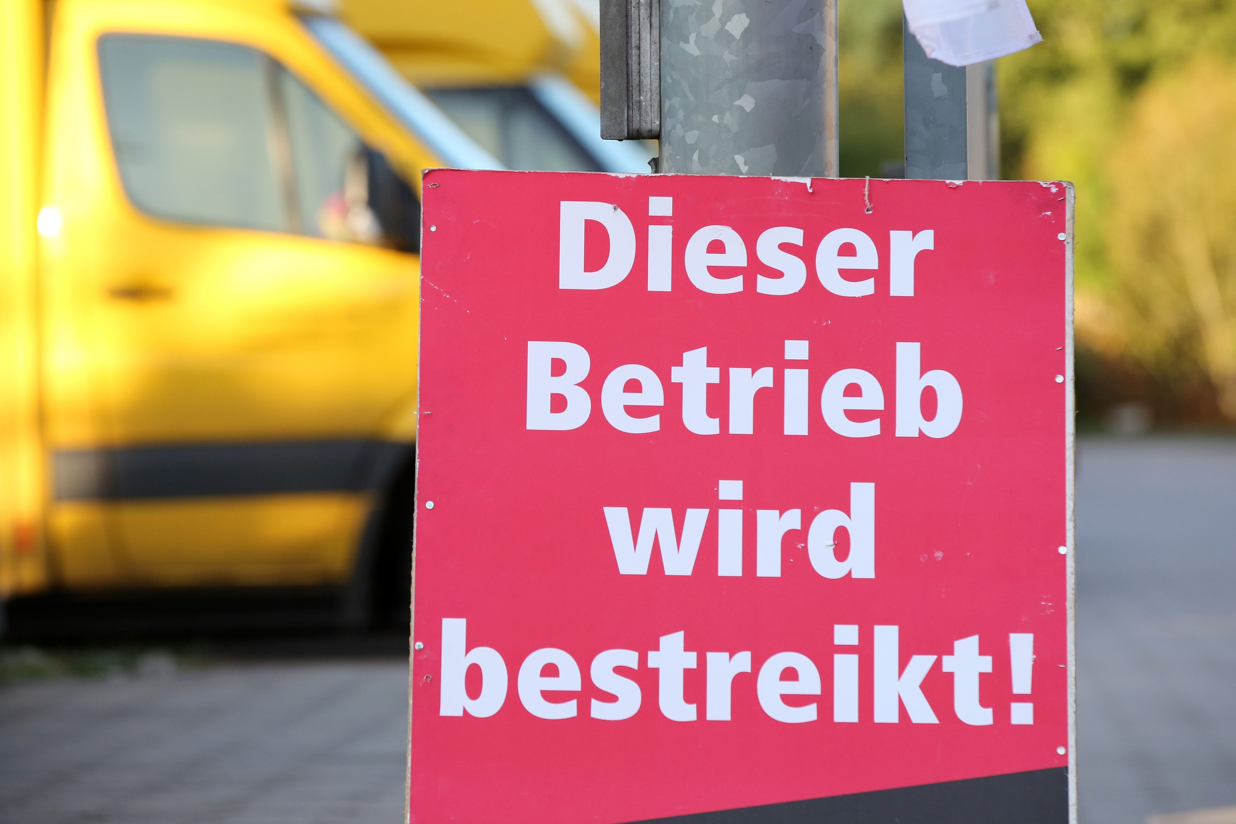 Ein Schild mit der Aufschrift „Dieser Betrieb wird bestreikt“ steht vor einer bestreikten Deutsche-Post-DHL-Niederlassung. (Archivbild)