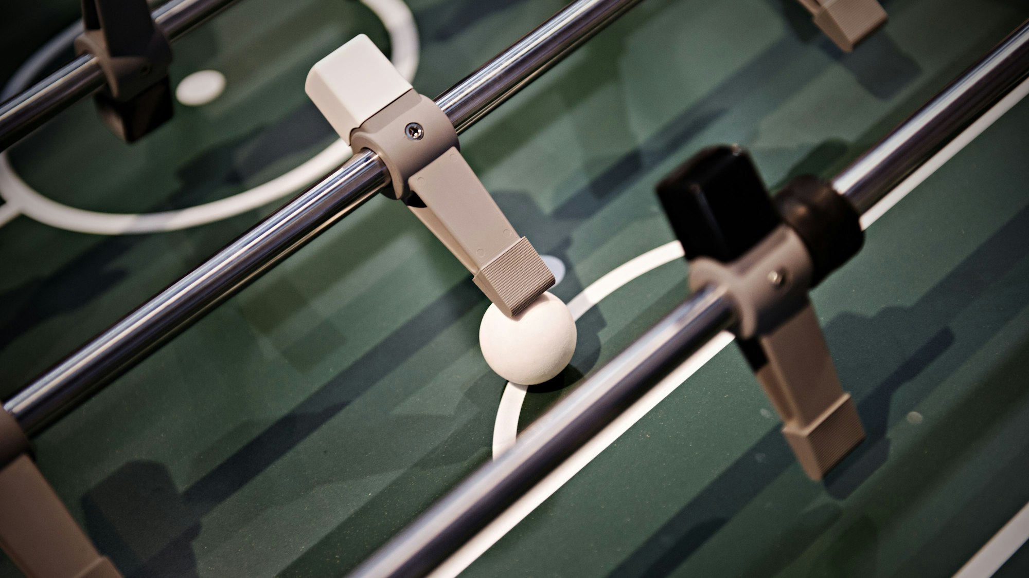 Eine Tischkickerfigur spielt den Ball.