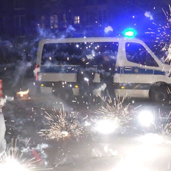 Polizeibeamte stehen hinter explodierendem Feuerwerk.