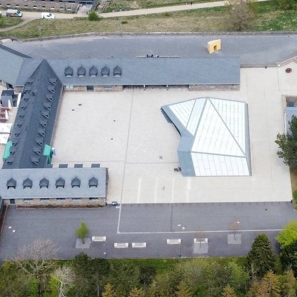 Blick aus der Luft auf das Besucherzentrum im Adlerhof mit der Glaskonstruktion, dessen Dach undicht ist.