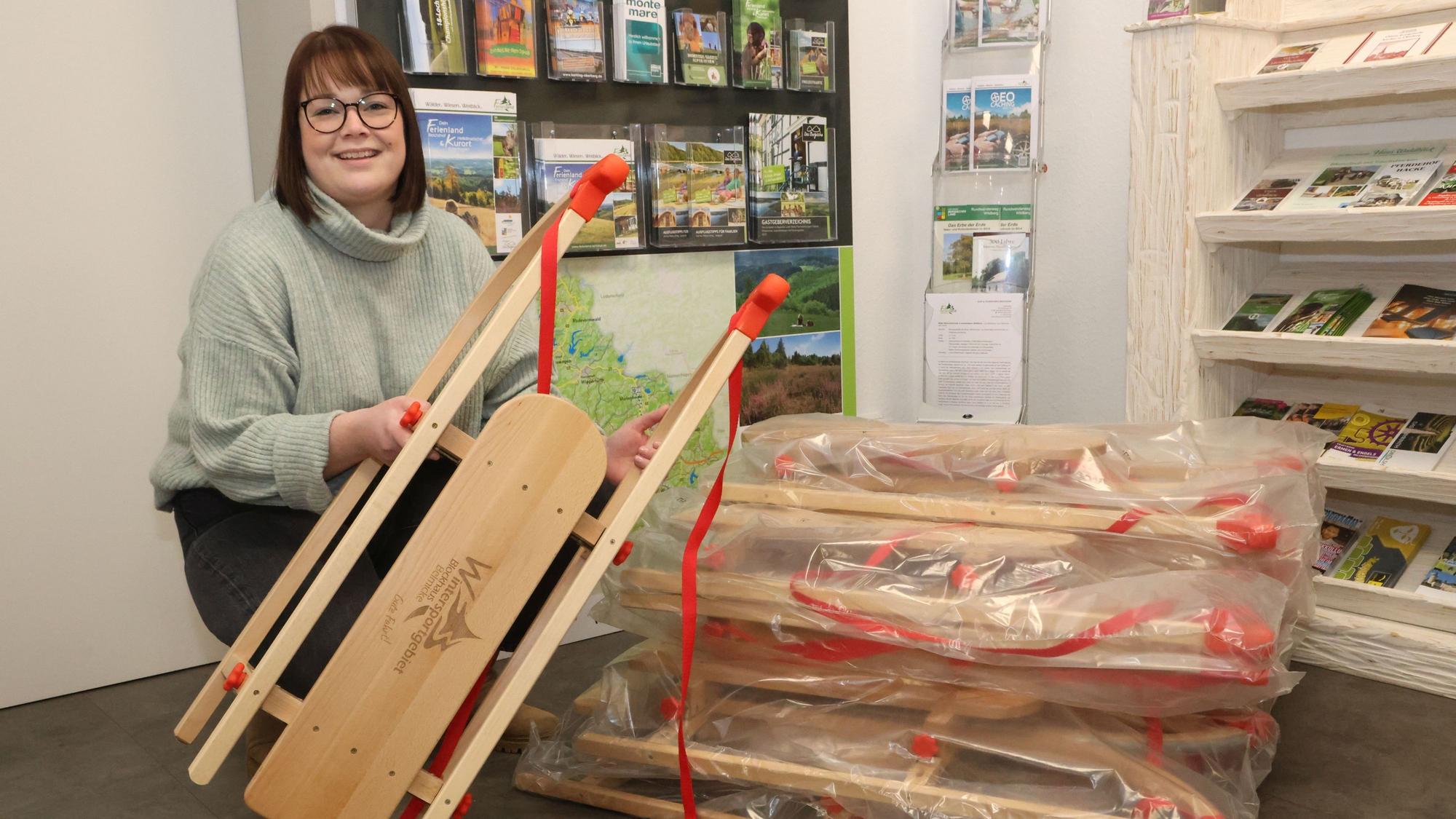 Eine Frau packt die Holzschlitten aus.