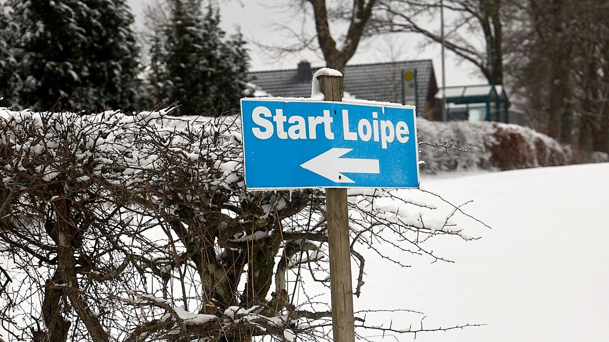 Auf einem blauen Schild steht Start Loipe.