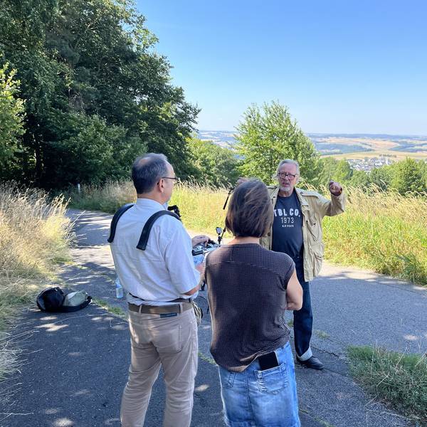 Ein Mann wird gefilmt, im Hintergrund ist Eifeler Landschaft zu sehen.