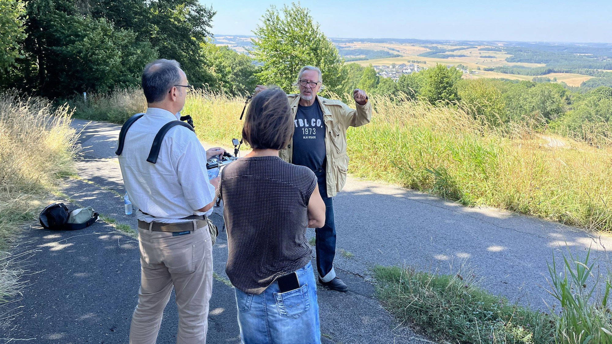 Ein Mann wird gefilmt, im Hintergrund ist Eifeler Landschaft zu sehen.
