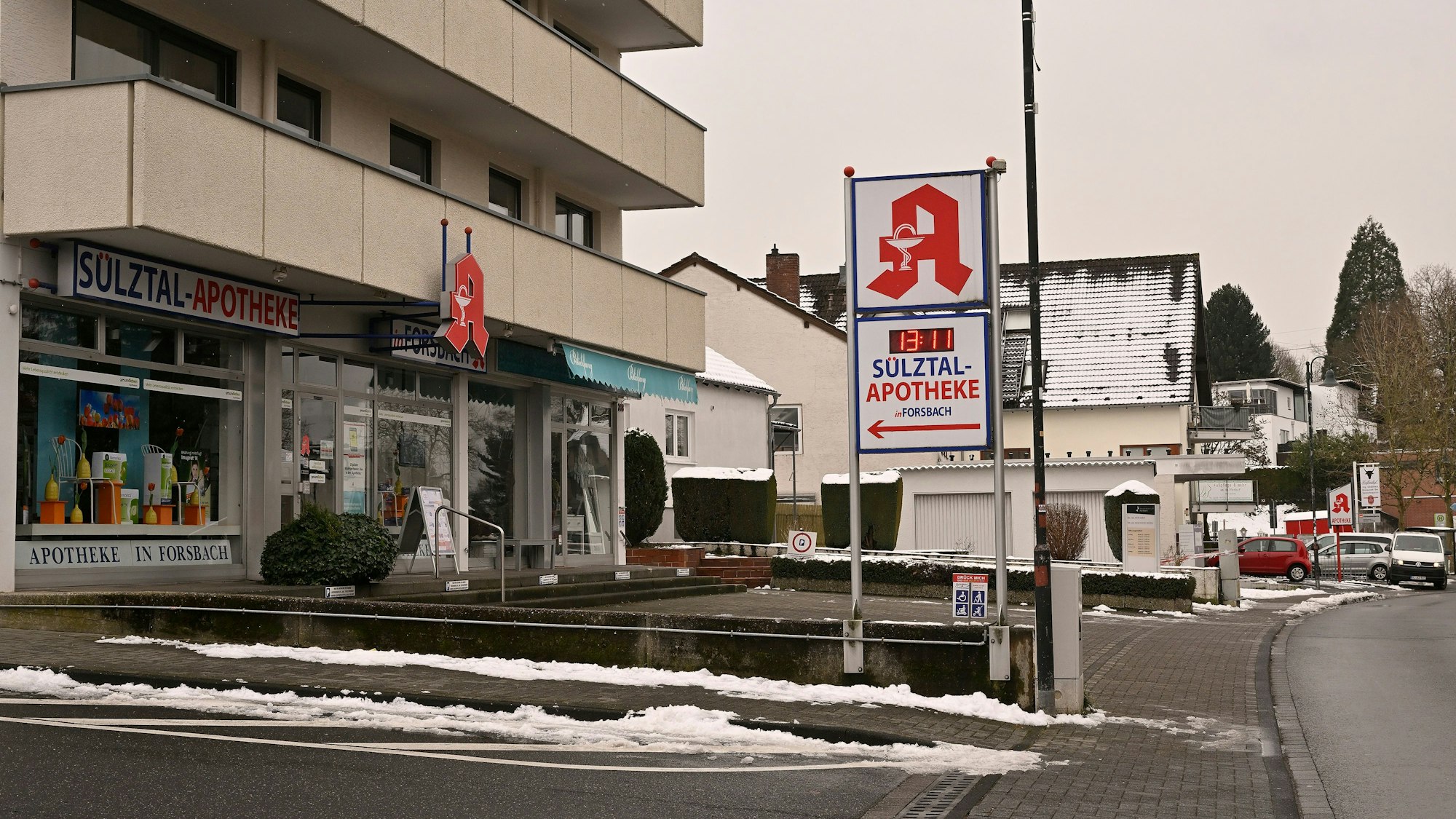 Der Parkplatz einer Apotheke ist leer. Nur ein paar Meter weiter hinten ist das Schild der nächsten Apotheke zu sehen.