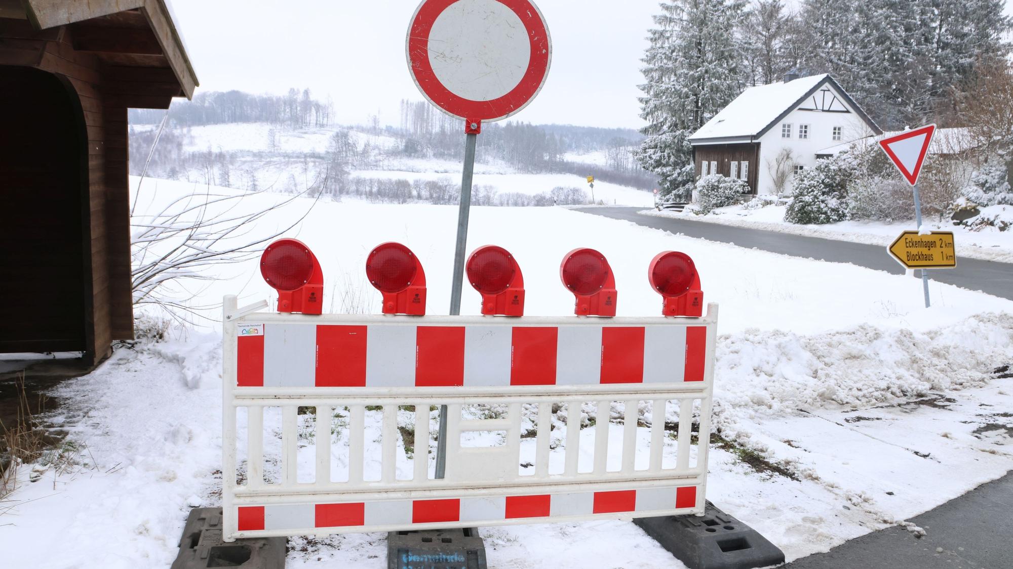 Im Bild ist eine Absperrbarke neben einer Straße zu sehen.