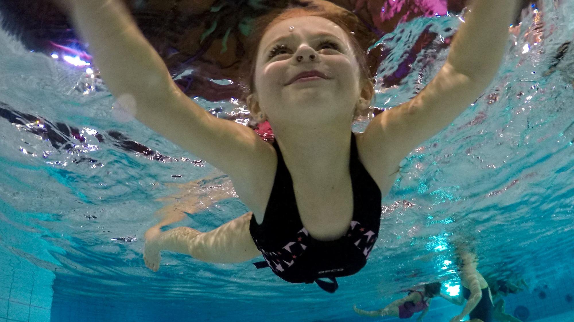 Ein Kind schwimmt in einem Schwimmbecken.