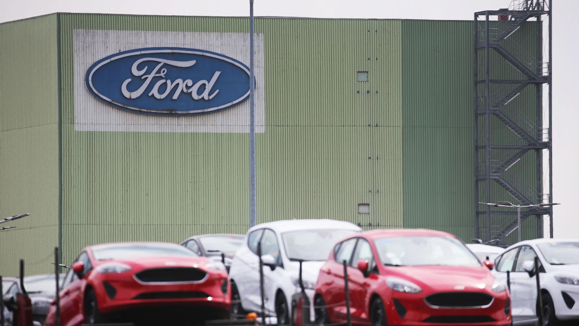 Neugebaute Autos stehen auf Lastwagen vor dem Ford-Werk in Köln.