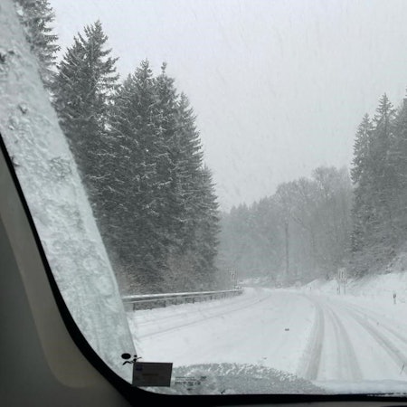 Blick aus einem Autofenster auf zugeschneite Straßen am Weißen Stein in Udenbreth
